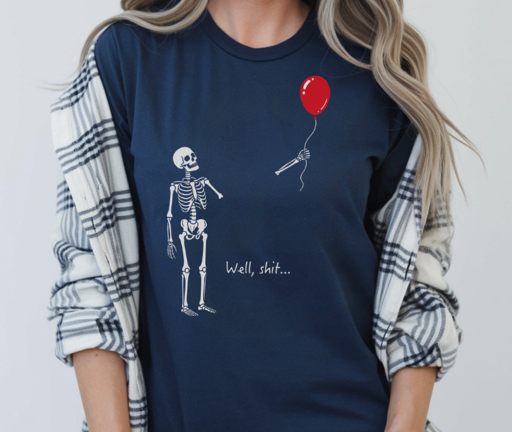 Funny shirt featuring Well Shit quote with skeleton losing an arm holding a balloon