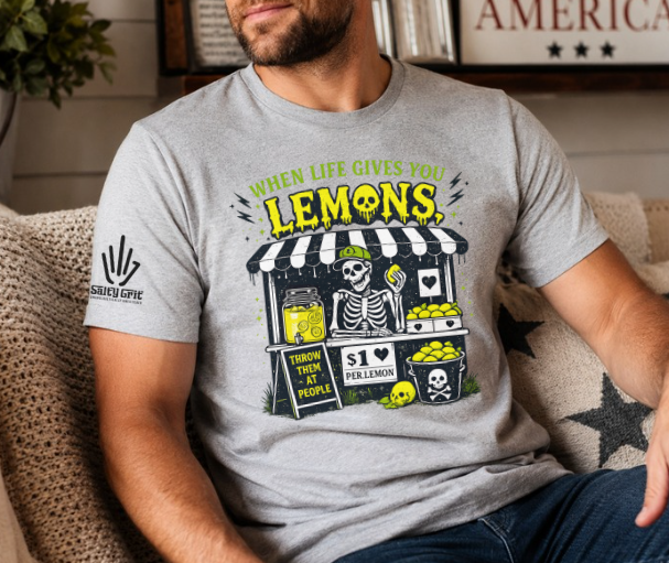 Funny shirt featuring When Life Gives You Lemons Throw Them At People with a skeleton at a lemonade stand